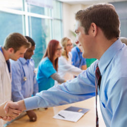 Hospital doctors, nurses, administrators having staff meeting in board room